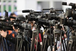 TV cameras lined up, covering large public event